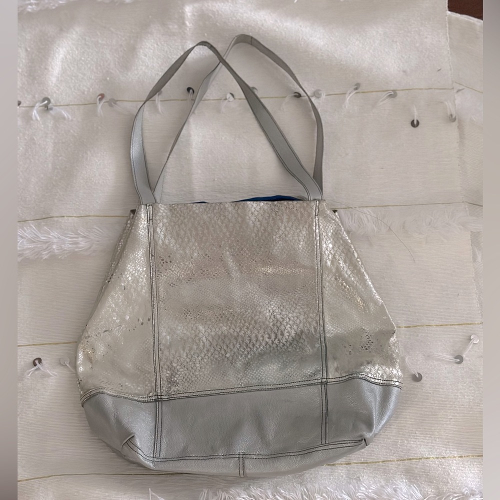 Silver fashion hand bag, blue interior. letter from a known brand in Colombia